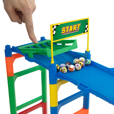Hand releasing decorated Impact Marble Racing DIY marbles from the green START gate of a colorful marble racing track.